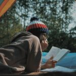 woman reading book in tent