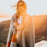 woman standing wearing gray and brown coat